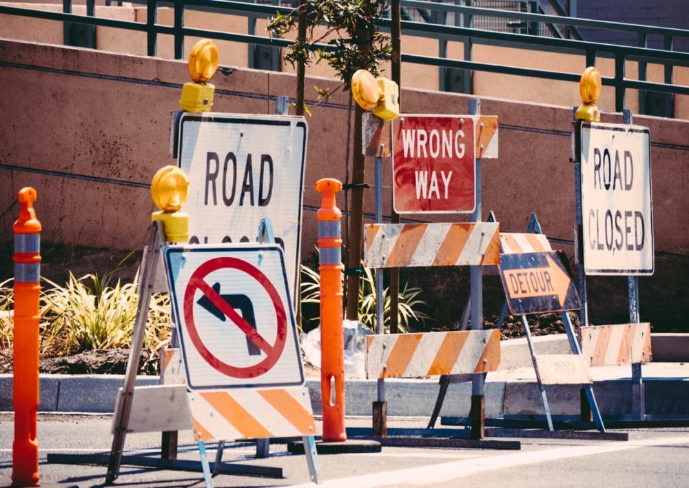 No left turn, road closed and wrong way street signs on a road