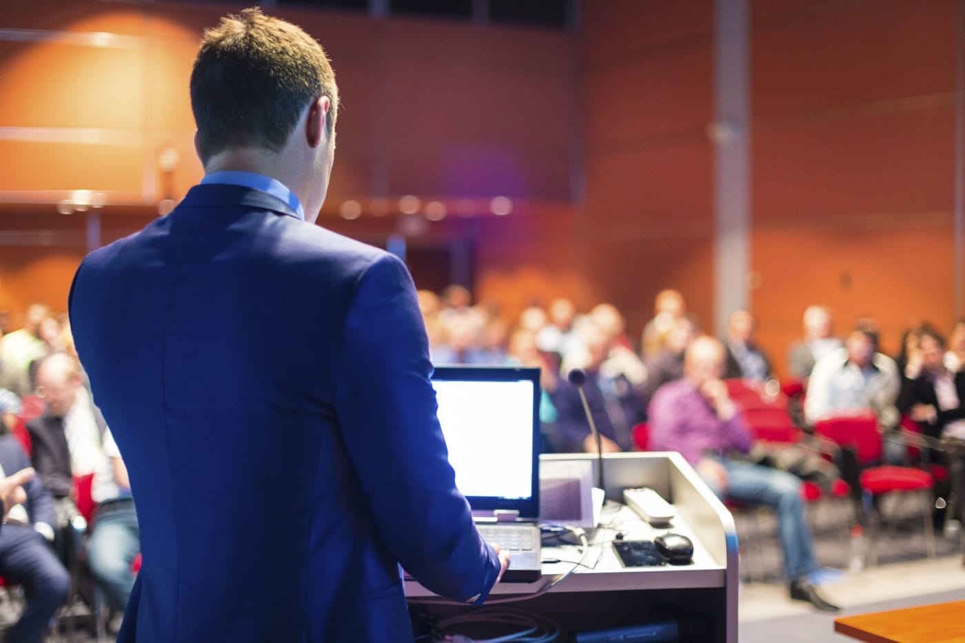 Man behind podium speaking at a convention